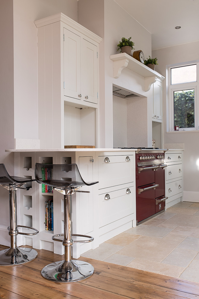 This is an example of a mid-sized traditional separate kitchen in Gloucestershire with shaker cabinets, light wood cabinets, quartzite benchtops and ceramic floors.