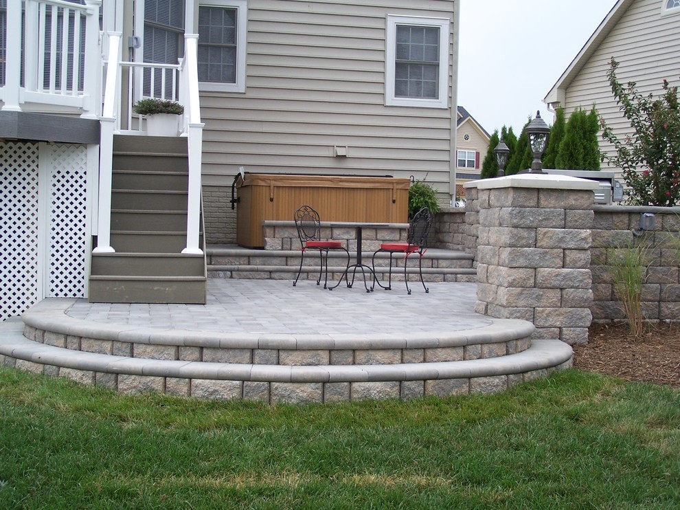 This is an example of a mid-sized traditional backyard patio in DC Metro with natural stone pavers and no cover.