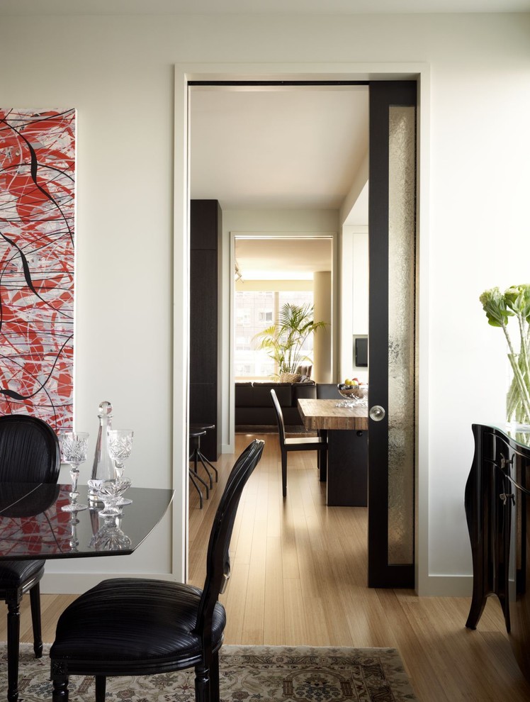 Photo of a contemporary dining room in New York with white walls and light hardwood floors.