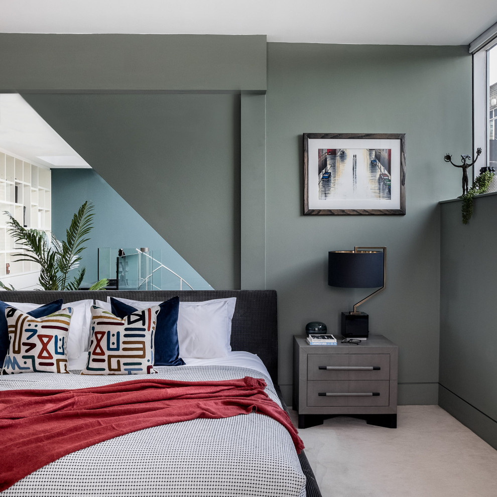 Photo of a large contemporary master bedroom in London with green walls, carpet and grey floor.