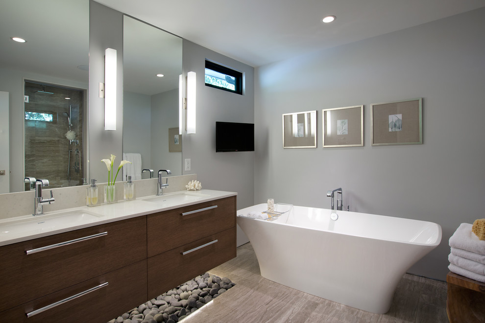 This is an example of a mid-sized modern master bathroom in Vancouver with an undermount sink, flat-panel cabinets, dark wood cabinets, a freestanding tub, grey walls, porcelain floors, engineered quartz benchtops and white benchtops.