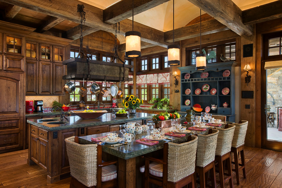 Example of a mountain style l-shaped eat-in kitchen design with raised-panel cabinets and dark wood cabinets