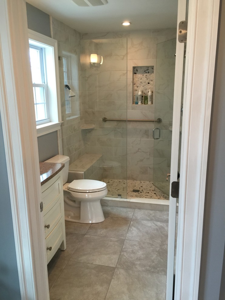 Photo of a mid-sized traditional 3/4 bathroom in Philadelphia with beaded inset cabinets, white cabinets, an alcove shower, a two-piece toilet, gray tile, ceramic tile, grey walls, an undermount sink, granite benchtops, a hinged shower door, a shower seat and a single vanity.