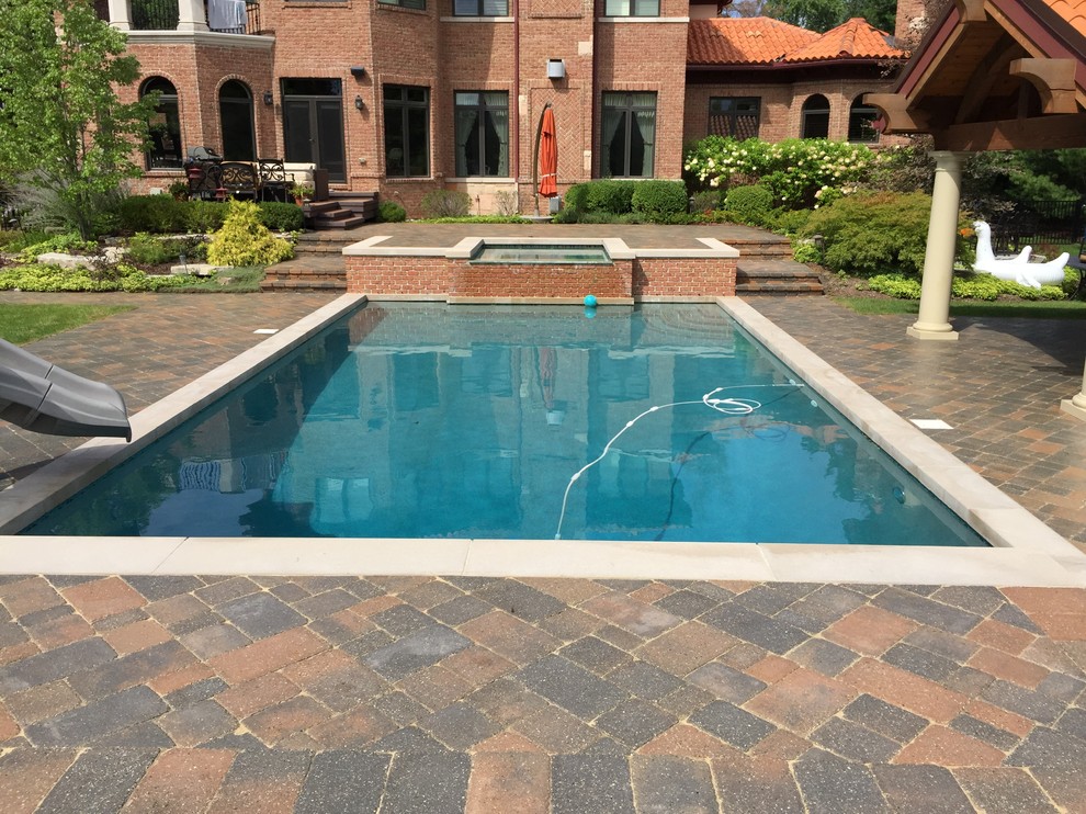 Design ideas for a large backyard pool in Detroit with brick pavers.