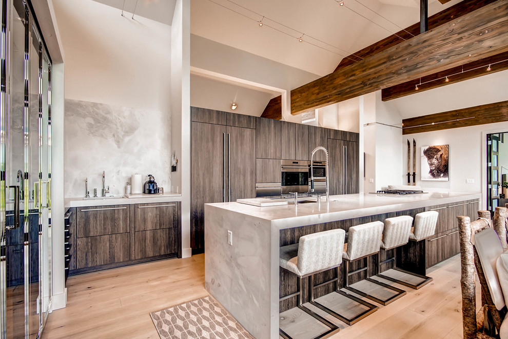 Photo of a contemporary galley eat-in kitchen in Denver with flat-panel cabinets, grey cabinets, stainless steel appliances, light hardwood floors and with island.