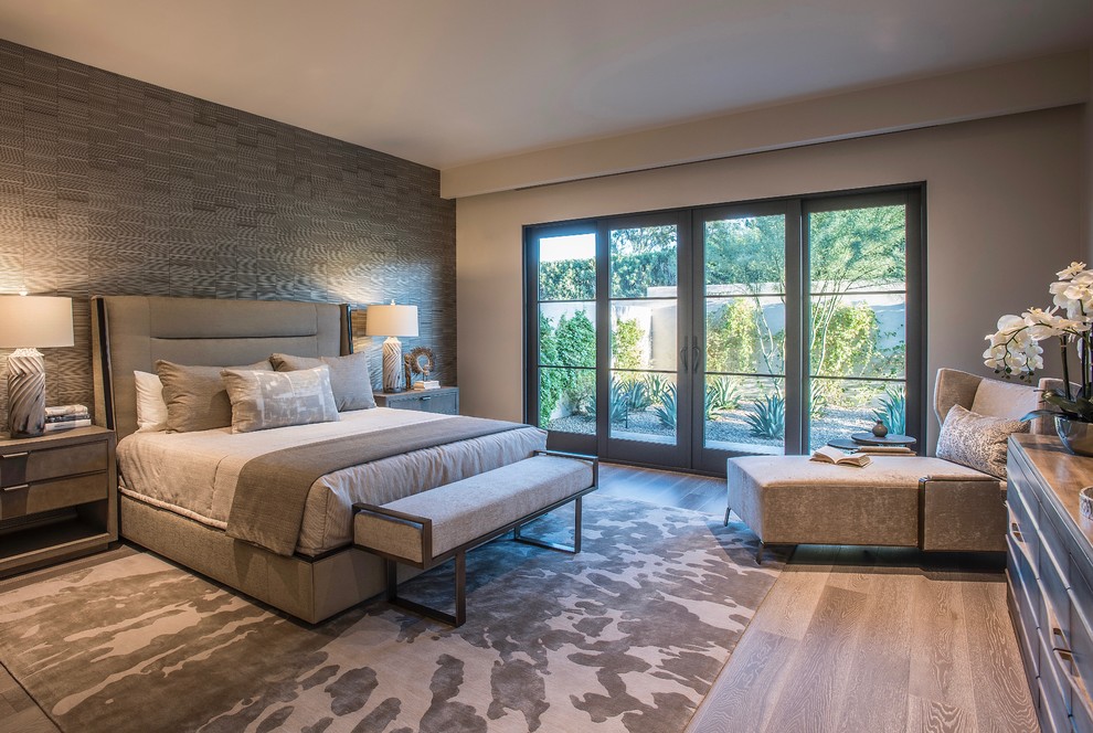 Large contemporary master bedroom in Phoenix with beige walls, medium hardwood floors and beige floor.
