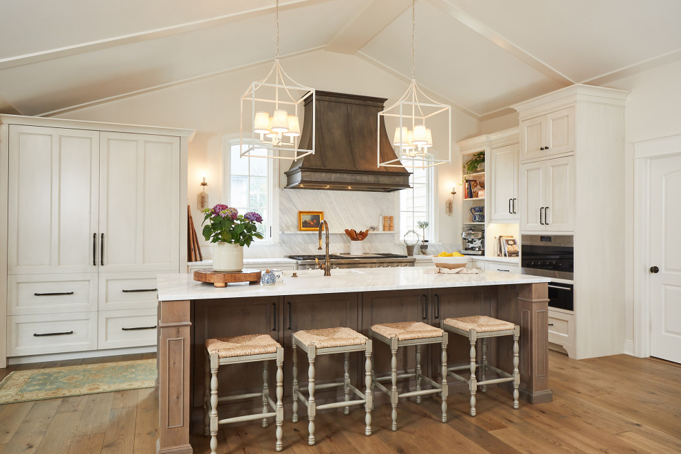 Eat-in kitchen - huge french country l-shaped light wood floor, white floor and vaulted ceiling eat-in kitchen idea in Grand Rapids with an undermount sink, recessed-panel cabinets, white cabinets, marble countertops, white backsplash, marble backsplash, paneled appliances, two islands and white countertops