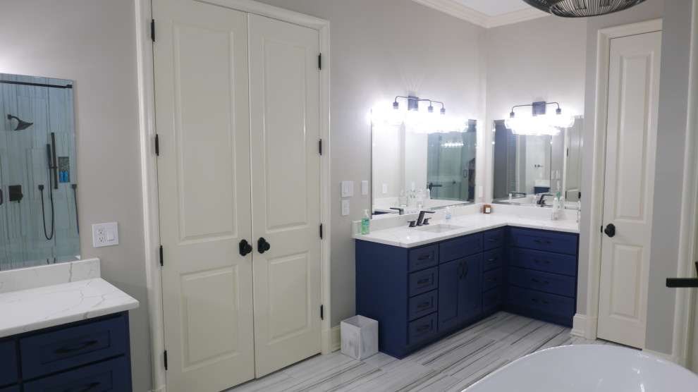 Идея дизайна: большая главная ванная комната в стиле неоклассика (современная классика) с фасадами в стиле шейкер, синими фасадами, отдельно стоящей ванной, двойным душем, унитазом-моноблоком, черно-белой плиткой, керамогранитной плиткой, серыми стенами, полом из керамогранита, врезной раковиной, столешницей из искусственного кварца, разноцветным полом, душем с распашными дверями, белой столешницей, нишей, тумбой под одну раковину и встроенной тумбой