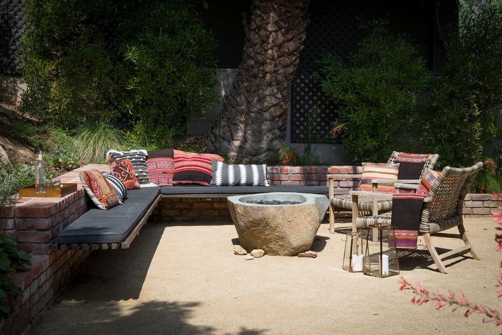 Photo of a mid-sized modern backyard partial sun xeriscape in Los Angeles with a fire feature.