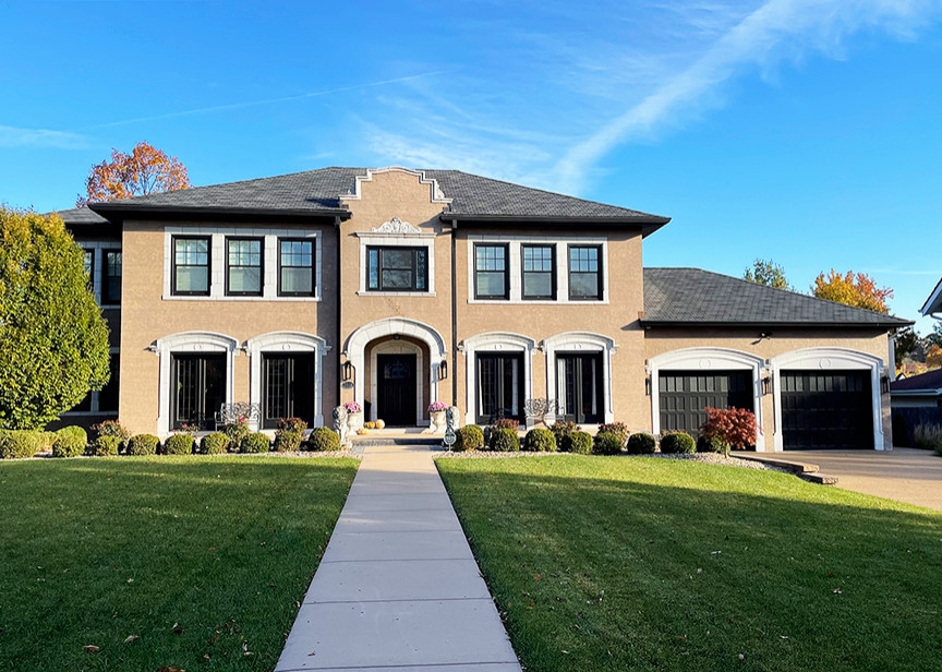Photo of a large and beige classic two floor painted brick detached house in St Louis with a hip roof, a shingle roof and a grey roof.