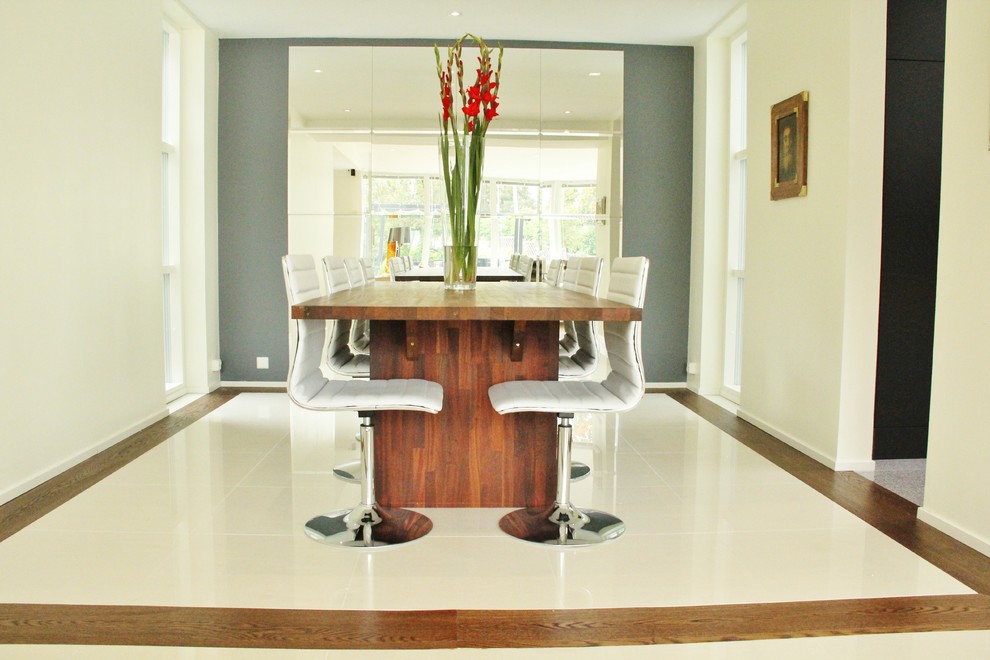 This is an example of a modern dining room in Other with beige walls and dark hardwood floors.
