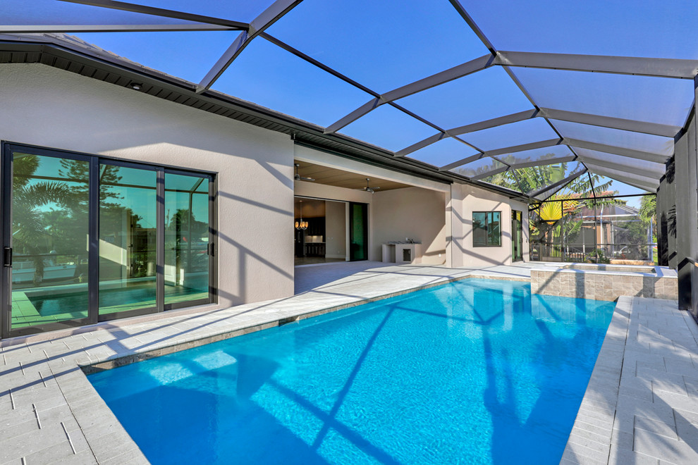 Example of a large transitional backyard concrete paver and rectangular hot tub design