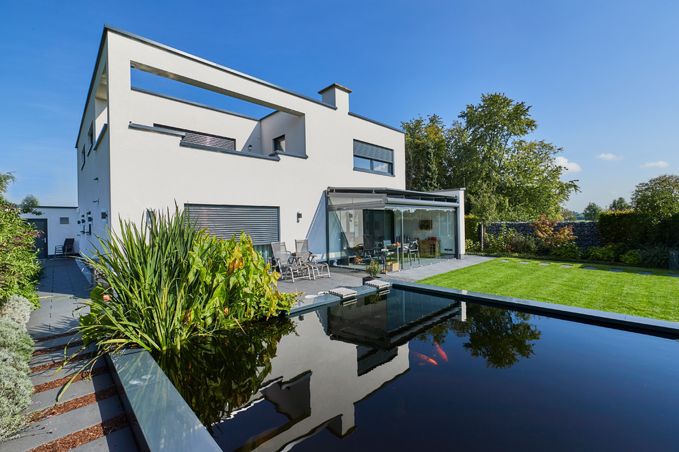 Inspiration for a mid-sized contemporary side yard rectangular aboveground pool in Essen with concrete slab.