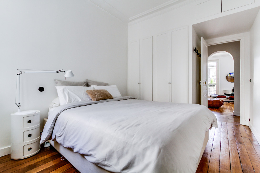 Inspiration pour une chambre parentale design de taille moyenne avec un mur blanc, parquet clair et un sol beige.