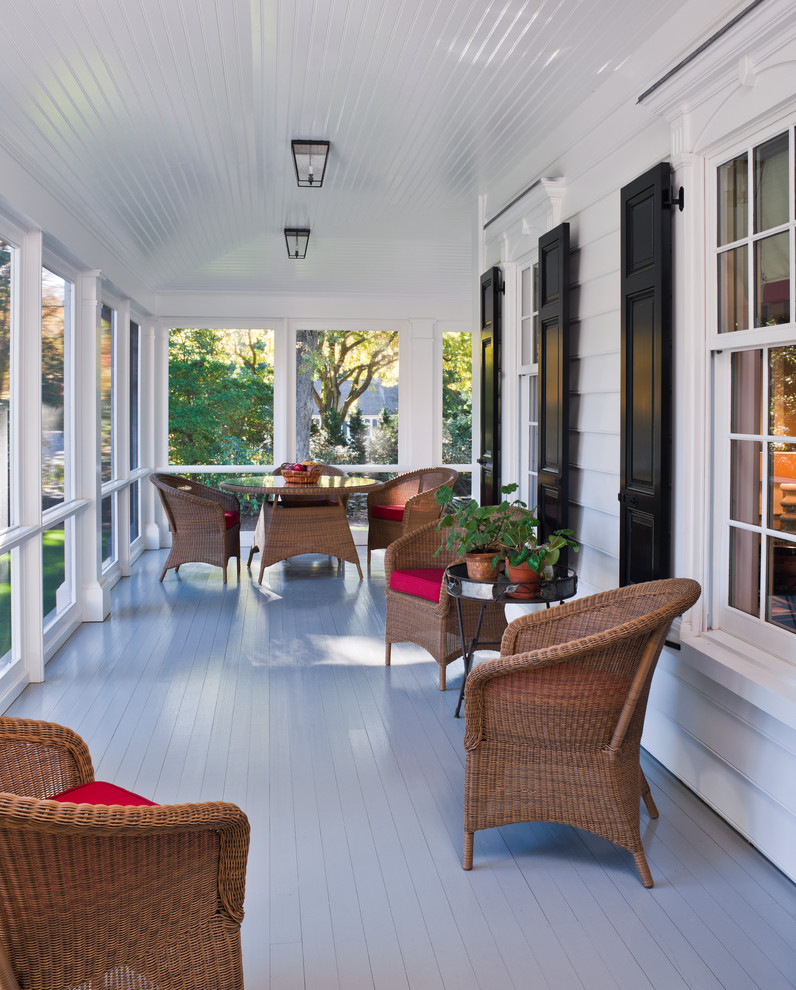 Photo of a large traditional side yard screened-in verandah in New York with decking and a roof extension.