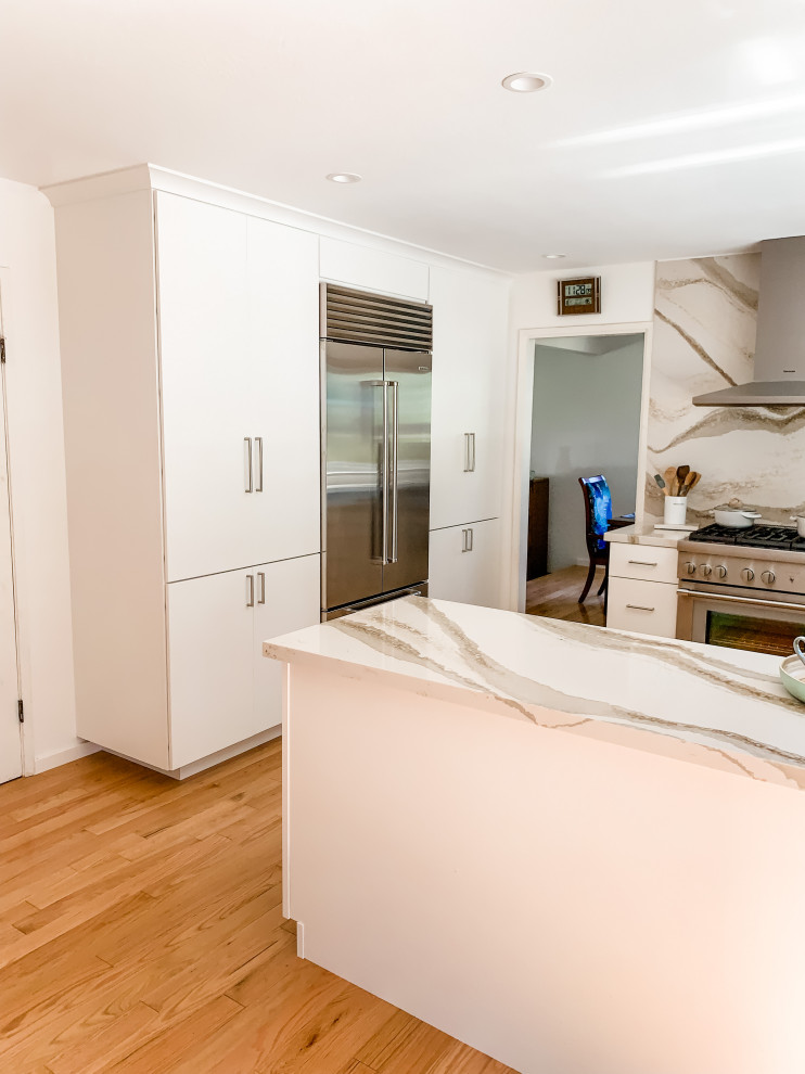 Photo of a small modern u-shaped kitchen in San Francisco with a double-bowl sink, flat-panel cabinets, white cabinets, quartz benchtops, white splashback, engineered quartz splashback, stainless steel appliances, light hardwood floors, a peninsula, beige floor and yellow benchtop.