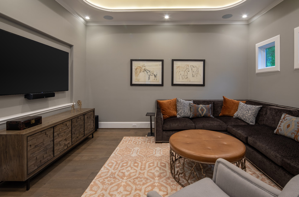 Photo of a transitional family room in Houston with grey walls, dark hardwood floors, a wall-mounted tv and brown floor.