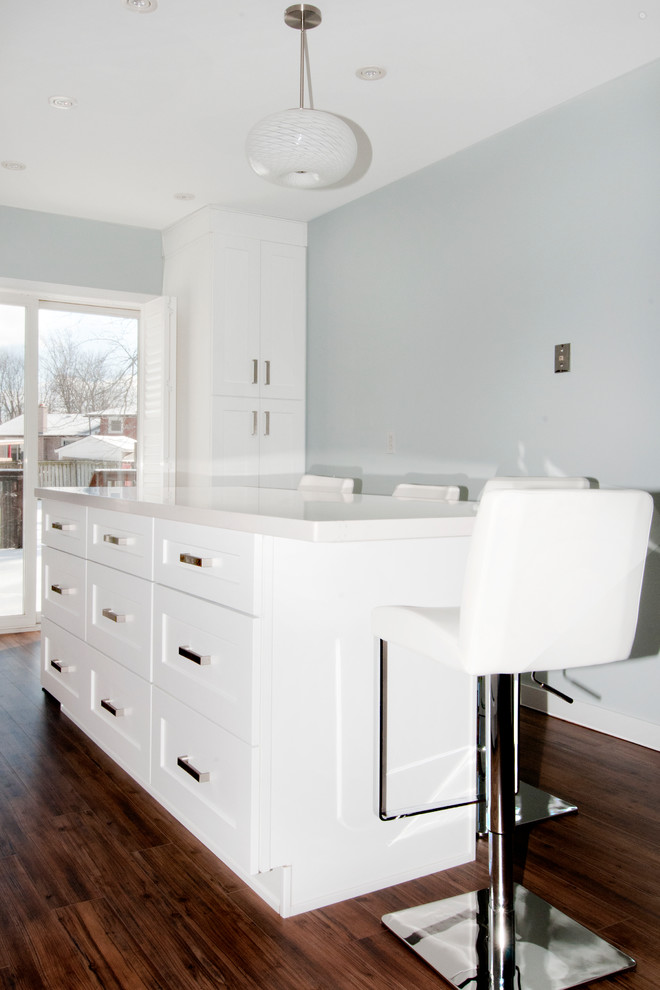 Kitchen - mid-sized transitional kitchen idea in Toronto with an undermount sink, shaker cabinets, white cabinets, quartz countertops, metallic backsplash, ceramic backsplash, white appliances, an island and white countertops