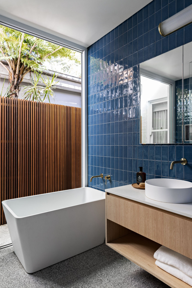 Design ideas for a small contemporary master bathroom in Sydney with open cabinets, light wood cabinets, a freestanding tub, an open shower, blue tile, ceramic tile, blue walls, terrazzo floors, engineered quartz benchtops, grey floor, an open shower, white benchtops, a single vanity and a floating vanity.