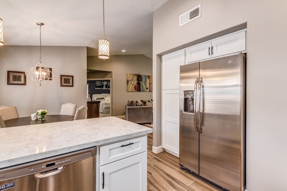 Kitchen pantry - mid-sized transitional u-shaped porcelain tile and beige floor kitchen pantry idea in Phoenix with a farmhouse sink, shaker cabinets, white cabinets, quartz countertops, white backsplash, subway tile backsplash, stainless steel appliances and white countertops