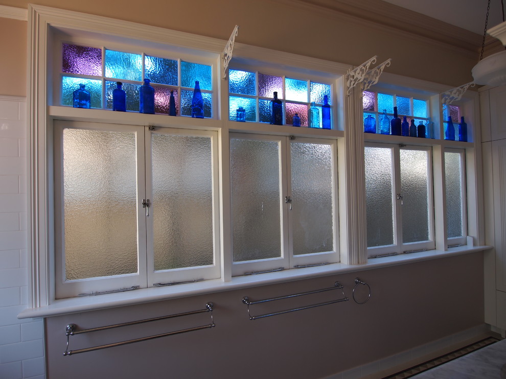 Mid-sized mediterranean master bathroom in Sydney with an integrated sink, furniture-like cabinets, white cabinets, granite benchtops, a claw-foot tub, a shower/bathtub combo, a two-piece toilet, blue tile, mosaic tile, beige walls and mosaic tile floors.