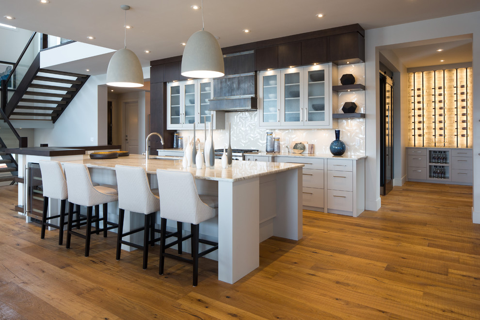 Inspiration for a large contemporary medium tone wood floor kitchen remodel in Calgary with an undermount sink, granite countertops, white backsplash, porcelain backsplash, white cabinets and two islands
