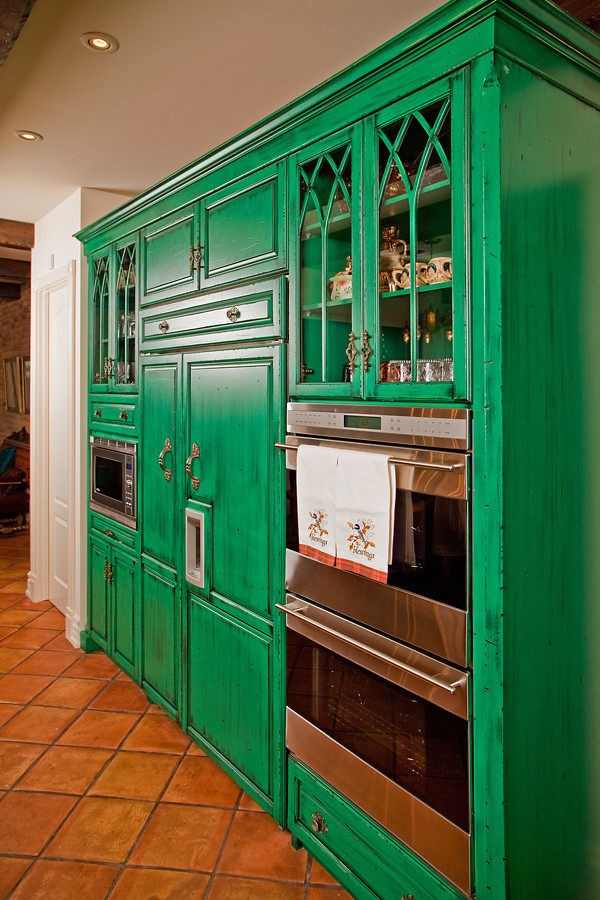 Inspiration for an eclectic kitchen in Toronto with glass-front cabinets, green cabinets and stainless steel appliances.