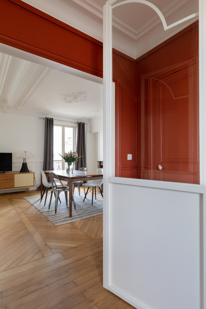 Idées déco pour une salle à manger ouverte sur le salon moderne de taille moyenne avec un mur blanc, un sol en bois brun, une cheminée standard, un manteau de cheminée en pierre et un sol marron.