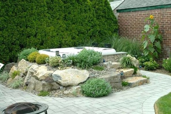 This is an example of a mid-sized transitional backyard patio in New York with natural stone pavers and no cover.