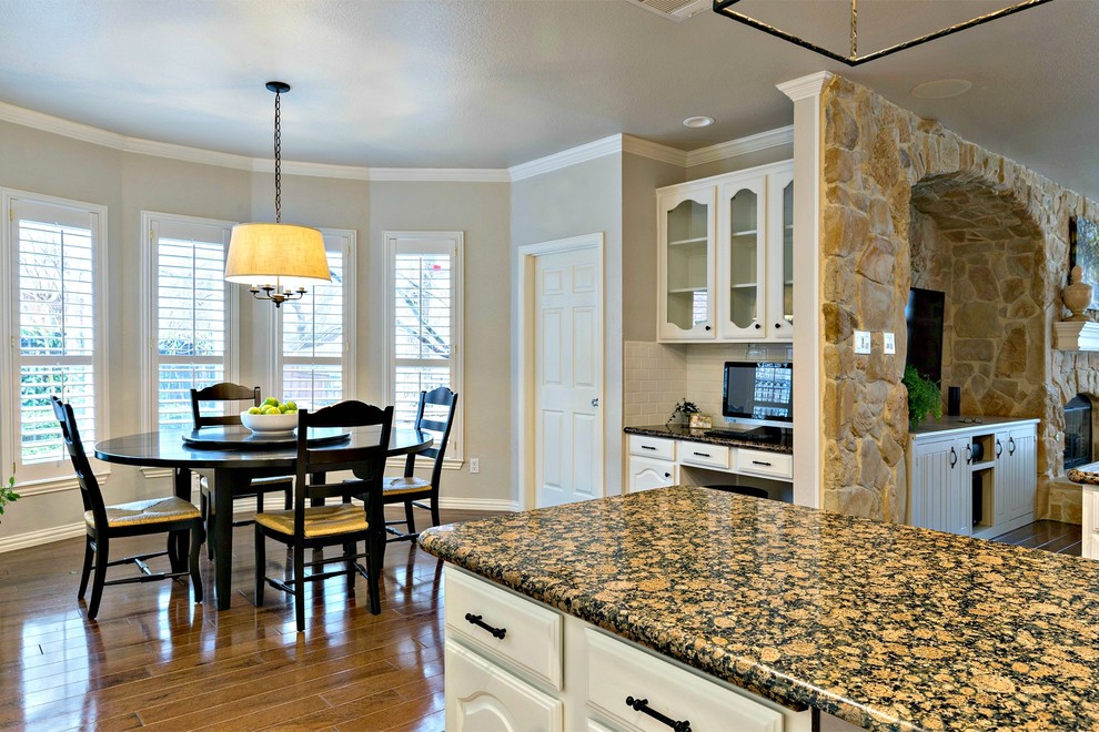 Open concept kitchen - large transitional galley medium tone wood floor open concept kitchen idea in Dallas with an undermount sink, white cabinets, granite countertops, white backsplash, subway tile backsplash, stainless steel appliances and two islands