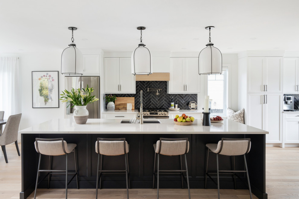 Idéer för ett stort klassiskt vit linjärt kök med öppen planlösning, med en undermonterad diskho, luckor med profilerade fronter, vita skåp, bänkskiva i kvarts, grått stänkskydd, stänkskydd i keramik, rostfria vitvaror, ljust trägolv, en köksö och brunt golv
