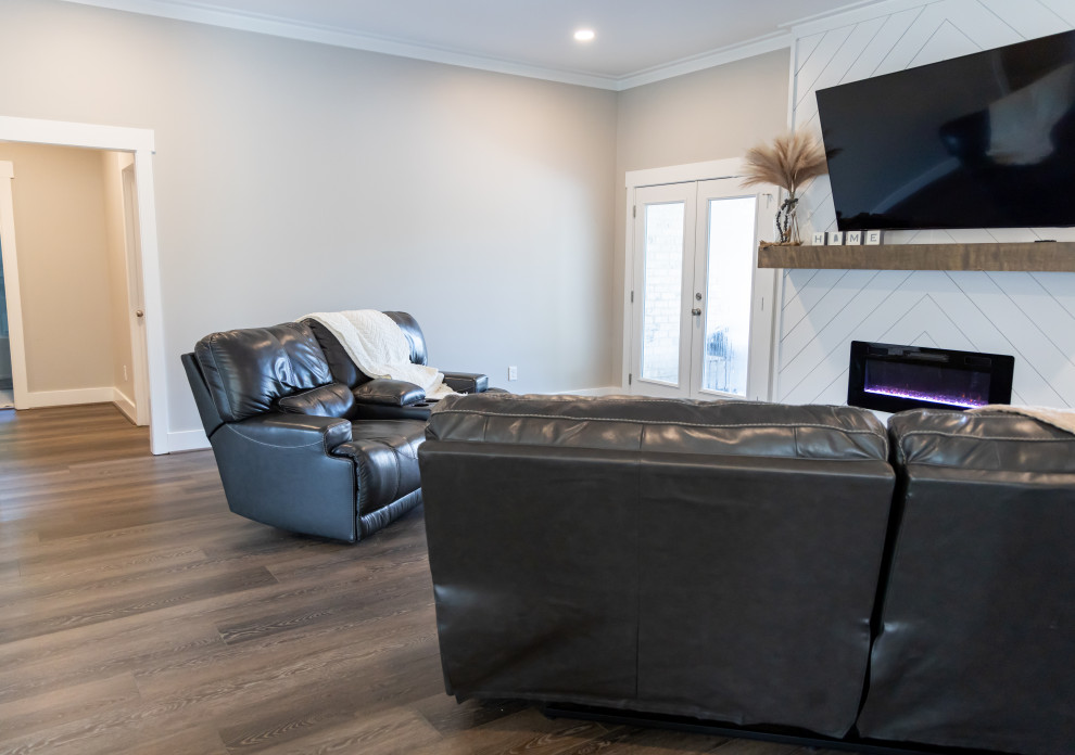 Photo of a small transitional formal open concept living room in Birmingham with white walls, vinyl floors, a standard fireplace, a concrete fireplace surround, a wall-mounted tv, brown floor and recessed.