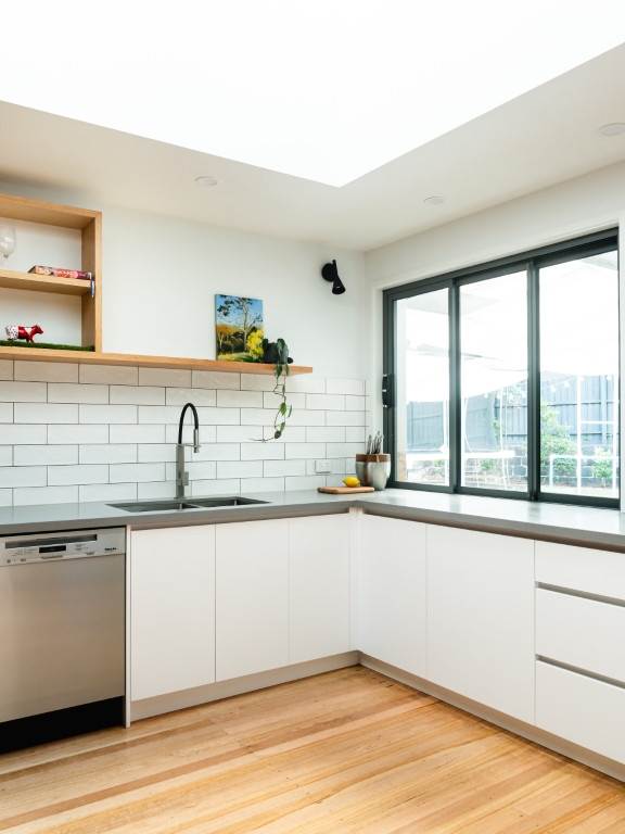 Idées déco pour une petite arrière-cuisine contemporaine en U avec un évier posé, un placard à porte plane, des portes de placard blanches, un plan de travail en surface solide, une crédence blanche, une crédence en carrelage métro, un électroménager en acier inoxydable, aucun îlot et un plan de travail gris.