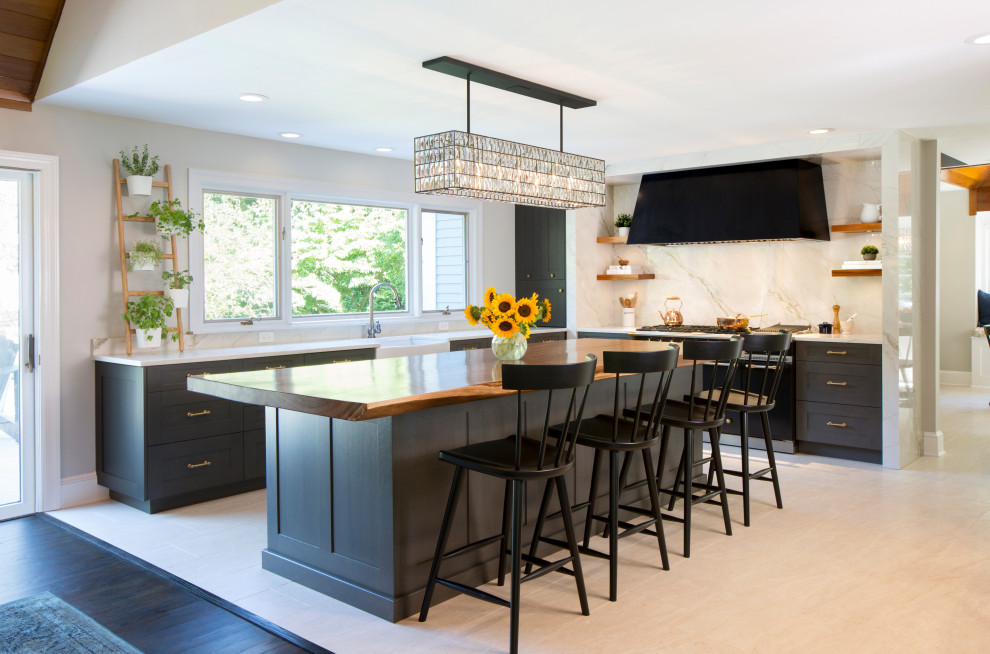 Large transitional l-shaped kitchen in Philadelphia with a farmhouse sink, shaker cabinets, dark wood cabinets, granite benchtops, stainless steel appliances, white splashback, granite splashback, with island, beige floor and white benchtop.