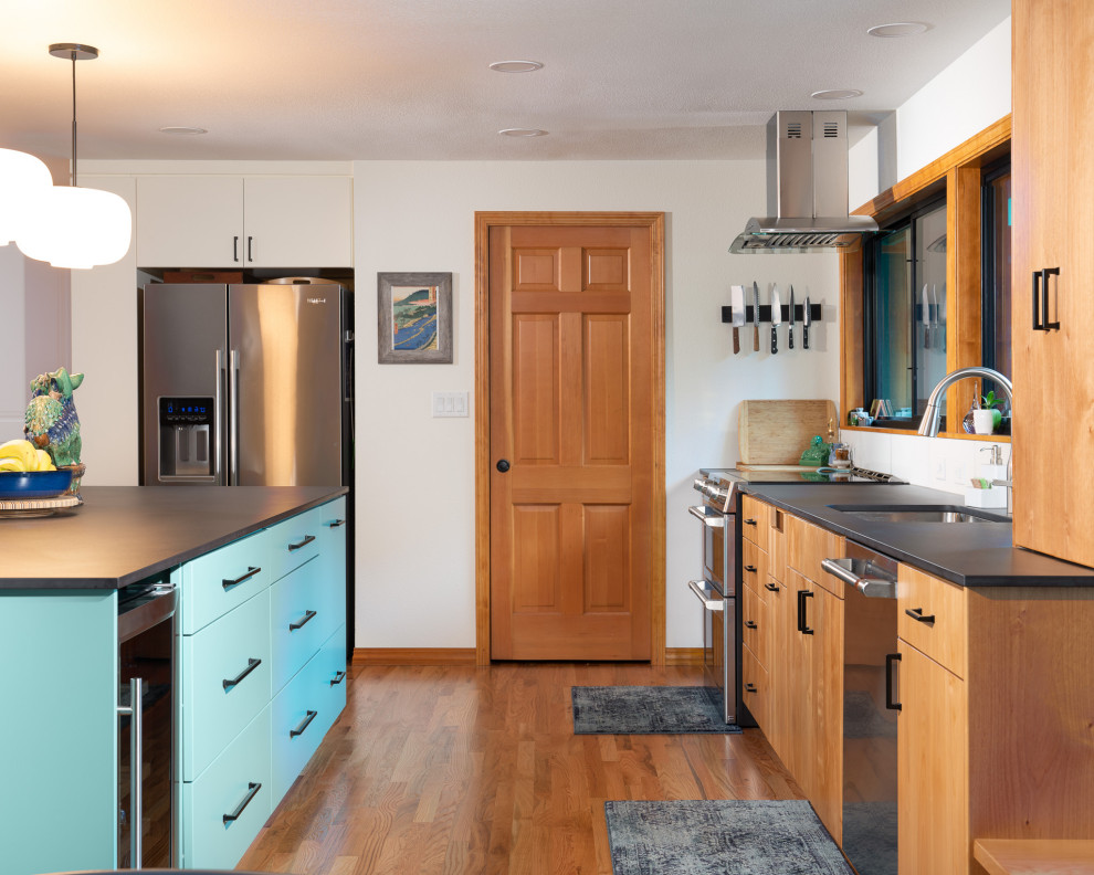 Inspiration for a large modern medium tone wood floor eat-in kitchen remodel in Other with an undermount sink, shaker cabinets, blue cabinets, quartzite countertops, white backsplash, ceramic backsplash, stainless steel appliances, an island and black countertops