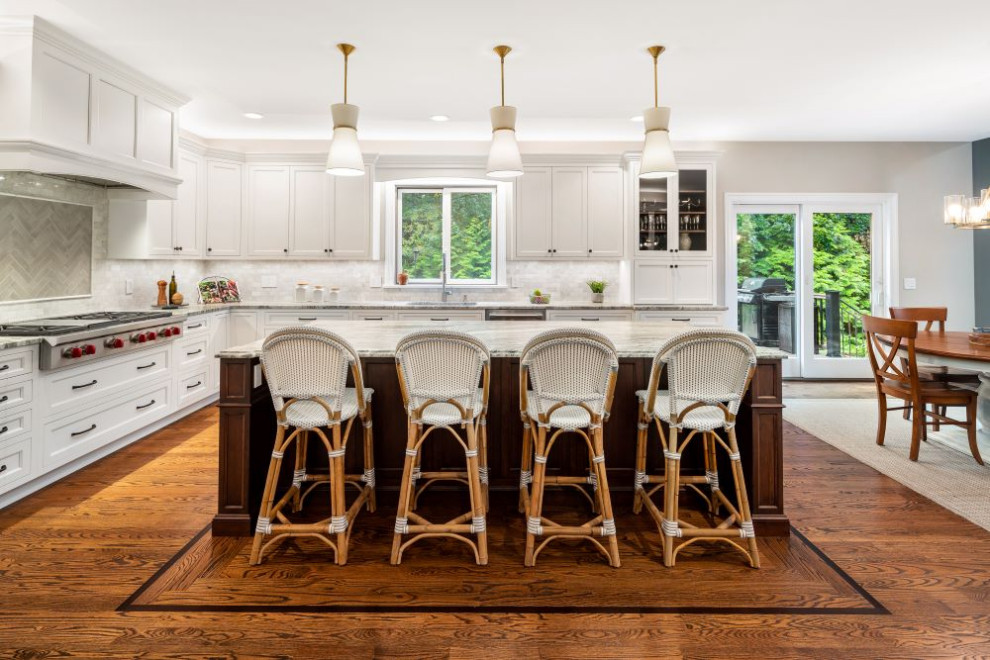 Example of a large transitional l-shaped eat-in kitchen design with stainless steel appliances, an island and gray countertops