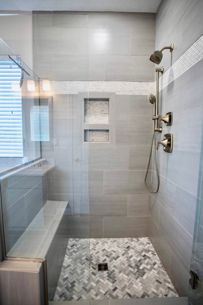 Photo of a mid-sized arts and crafts master bathroom in Cincinnati with shaker cabinets, grey cabinets, a corner shower, a two-piece toilet, gray tile, ceramic tile, beige walls, vinyl floors, an undermount sink, engineered quartz benchtops, grey floor, a hinged shower door, white benchtops, a shower seat, a double vanity and a built-in vanity.