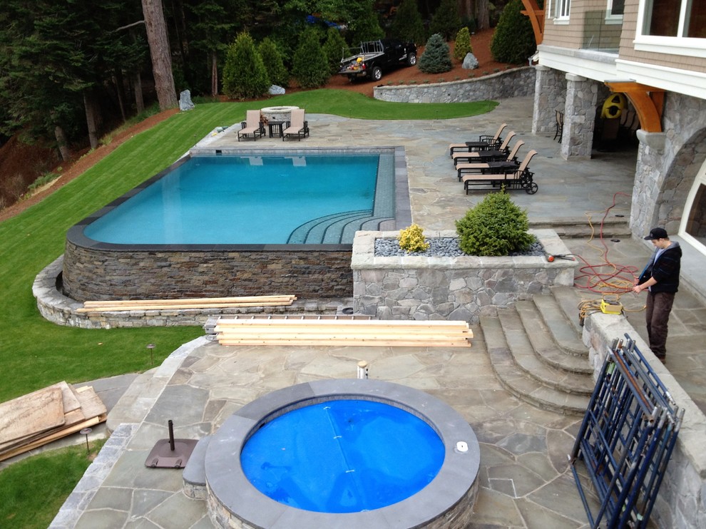 Hot tub - large transitional three-story and backyard mixed siding, stone and rectangular beige and infinity hot tub idea in Vancouver