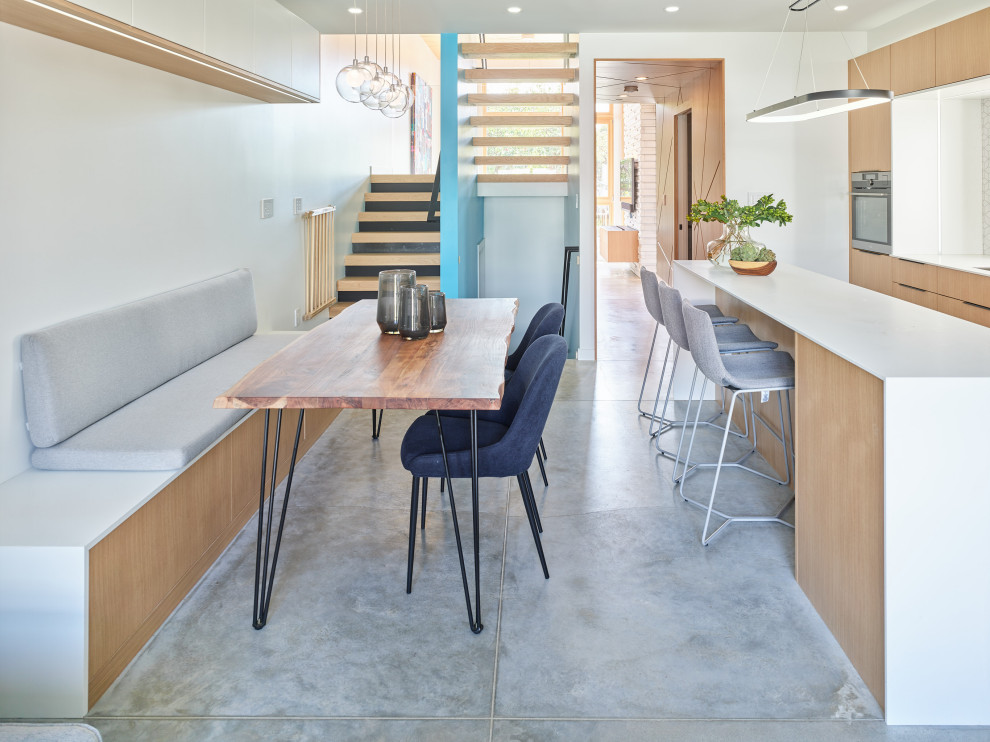 Small contemporary kitchen/dining combo in Vancouver with white walls, concrete floors, no fireplace and grey floor.