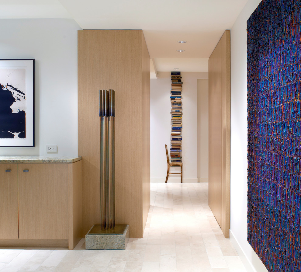 Photo of a contemporary hallway in Chicago with white walls, limestone floors, beige floor and panelled walls.