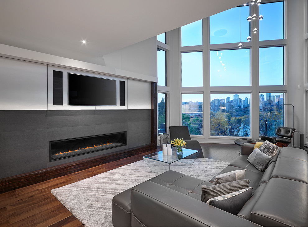 Large contemporary open concept living room in Edmonton with white walls, medium hardwood floors, a ribbon fireplace, a tile fireplace surround and a built-in media wall.