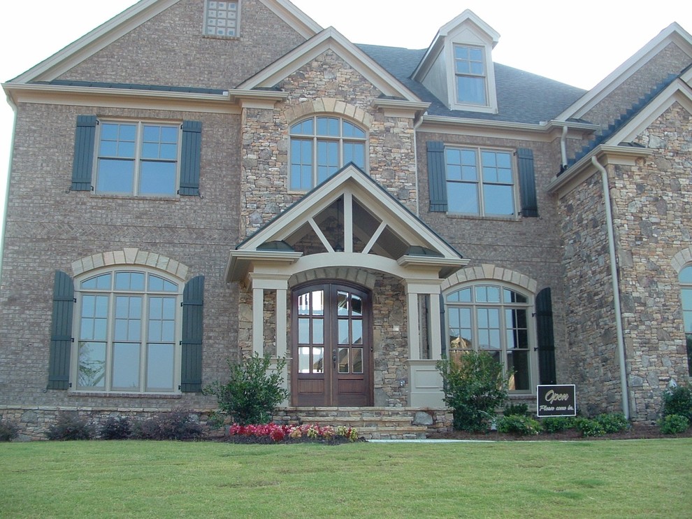 Traditional two-storey exterior in Atlanta with stone veneer.