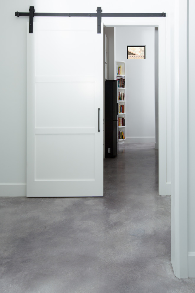 Photo of a modern hallway in Austin with concrete floors and grey floor.