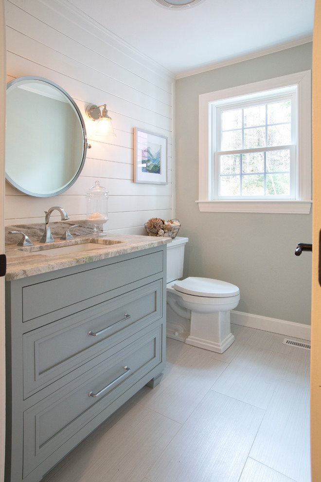 Photo of a mid-sized transitional 3/4 bathroom in Boston with beaded inset cabinets, blue cabinets, a two-piece toilet, gray tile, porcelain tile, green walls, porcelain floors, an undermount sink and quartzite benchtops.
