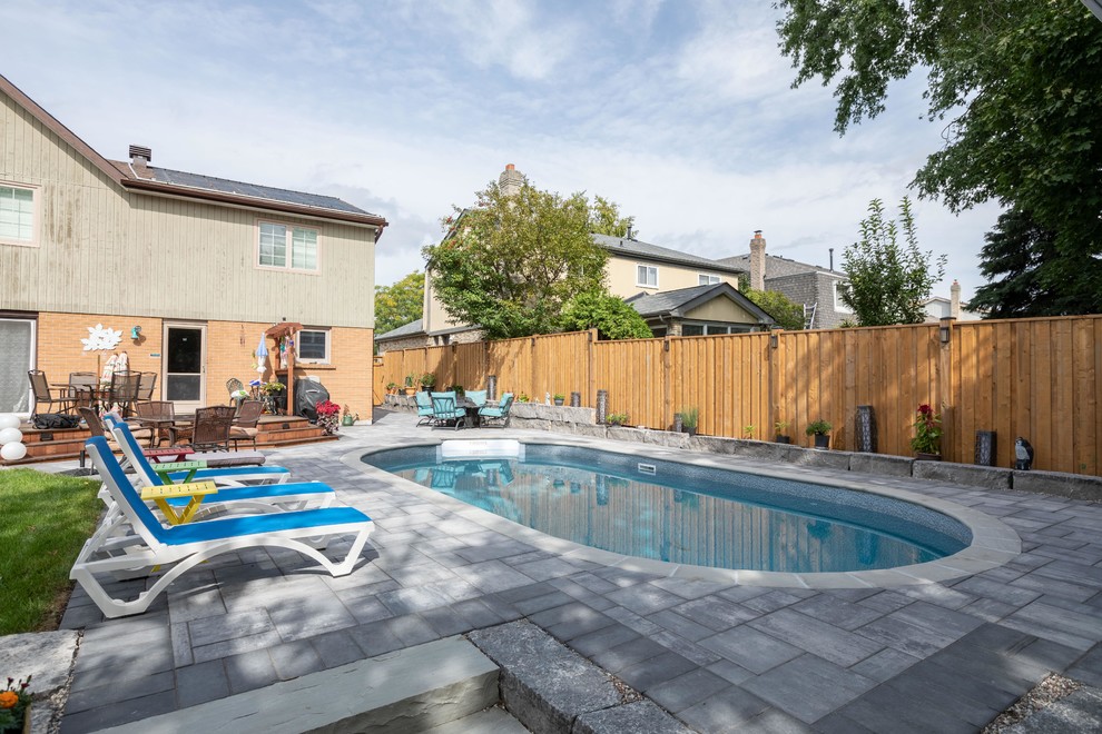 Design ideas for a modern backyard custom-shaped pool in Toronto with brick pavers.