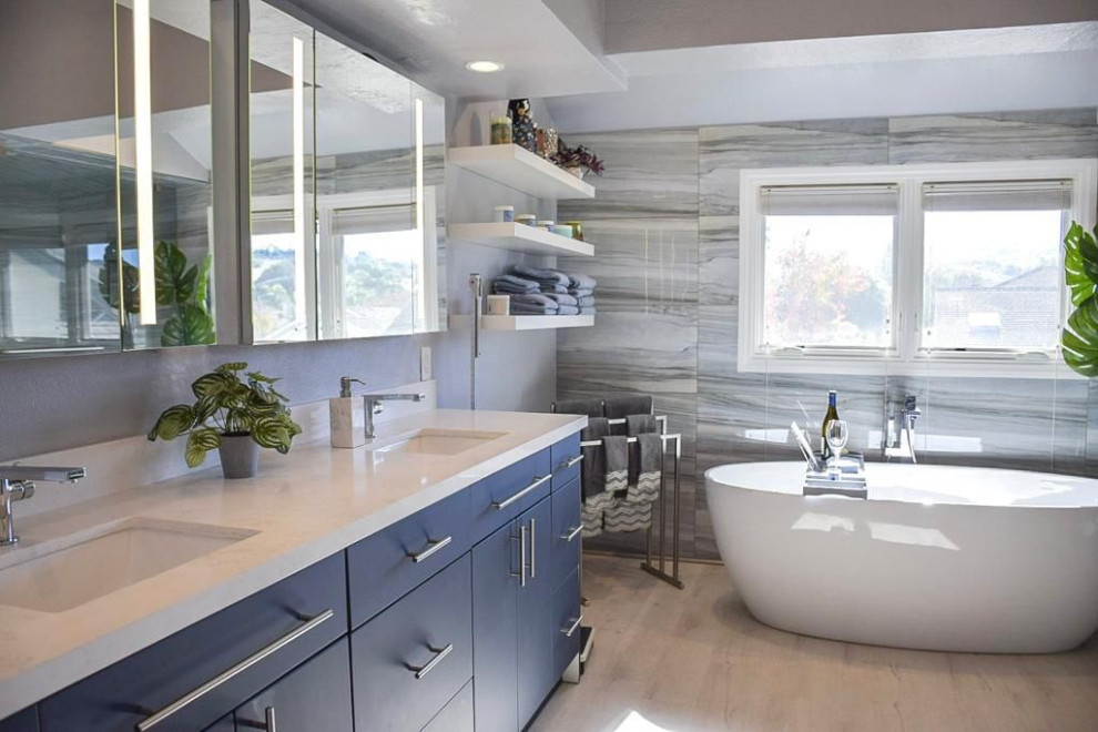 Foto di una stanza da bagno padronale etnica di medie dimensioni con vasca freestanding, piastrelle grigie, piastrelle di marmo, pareti grigie, top in marmo, pavimento beige, top bianco e due lavabi