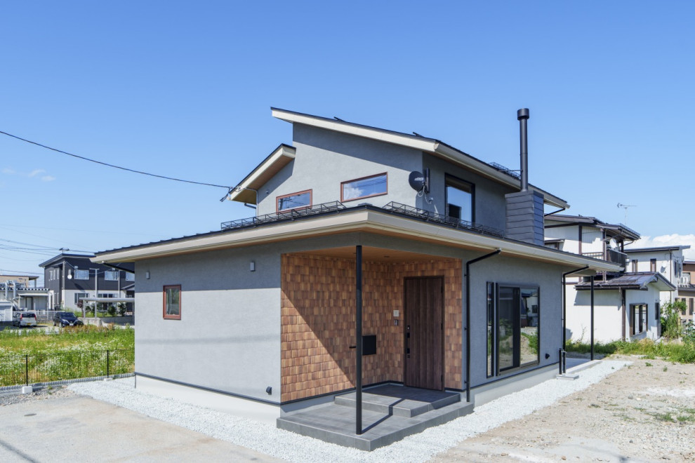Mittelgroßes, Zweistöckiges Asiatisches Einfamilienhaus mit grauer Fassadenfarbe, Mansardendach, Blechdach und schwarzem Dach in Sonstige