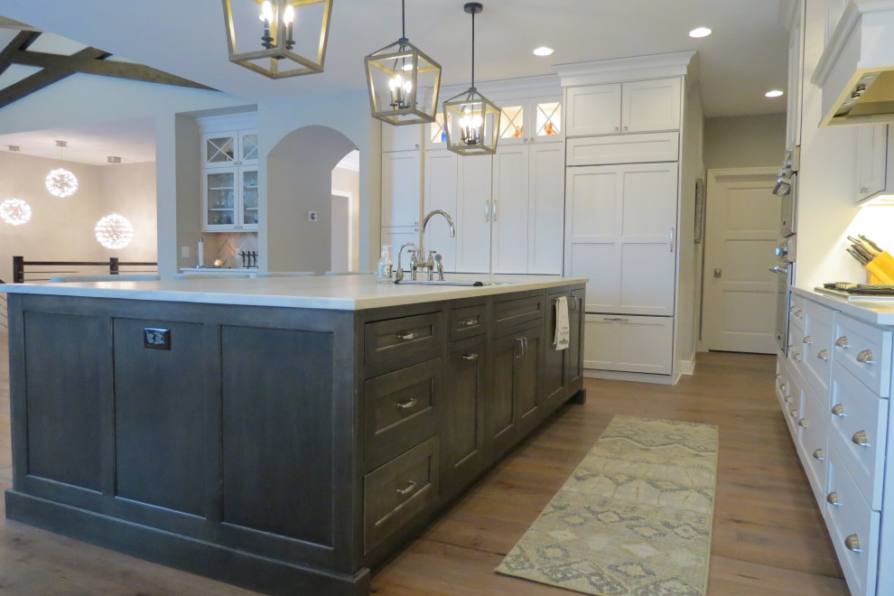 Inspiration for a large transitional l-shaped open plan kitchen in Detroit with an undermount sink, flat-panel cabinets, white cabinets, quartzite benchtops, grey splashback, stone tile splashback, stainless steel appliances, medium hardwood floors, with island, brown floor, grey benchtop and wood.