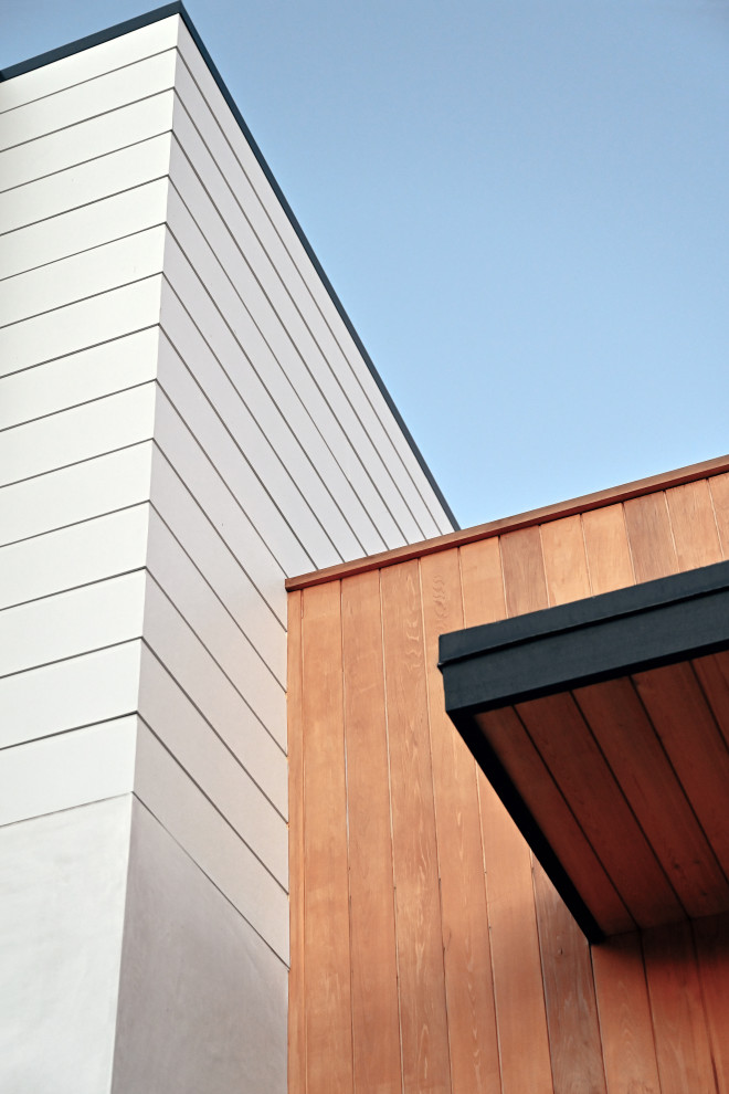 Mittelgroßes Maritimes Einfamilienhaus mit Mix-Fassade, Flachdach, Misch-Dachdeckung und grauem Dach in Orange County