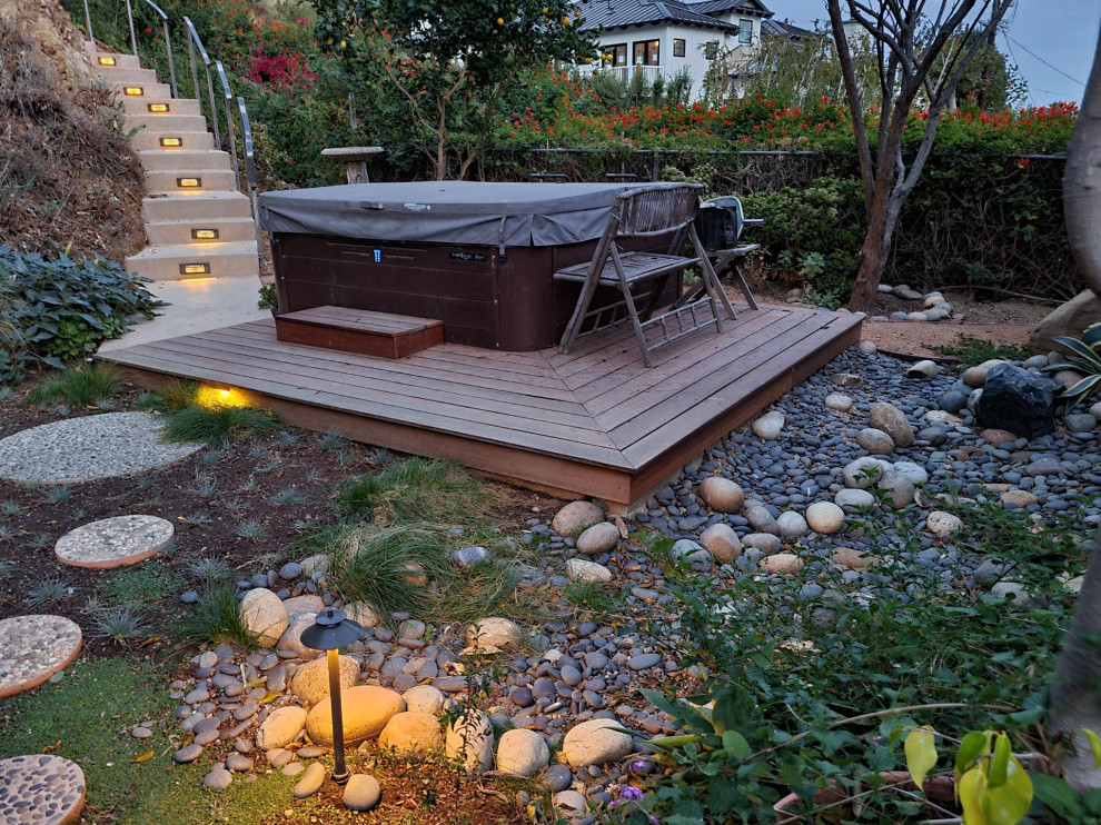 This is an example of a medium sized midcentury back xeriscape partial sun garden in Los Angeles with concrete paving and a metal fence.